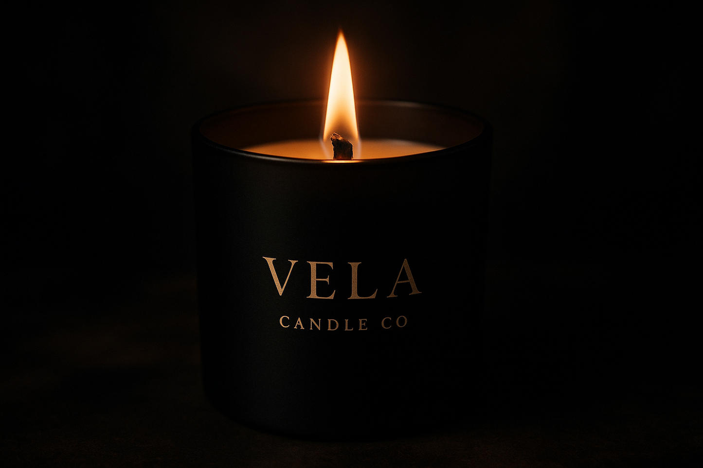 Romantic black candle vessel with a lit wooden wick  with the name Vela Candle Co on it, mysterious 